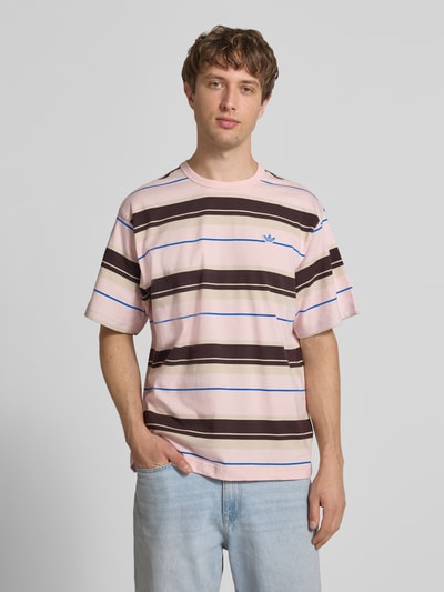 Männermodel trägt Regular Fit T-Shirt aus reiner Baumwolle von adidas Originals, mehrfarbig, gestreift, Logo-Stitching, Feinripp, Ganzkörperansicht von vorne.