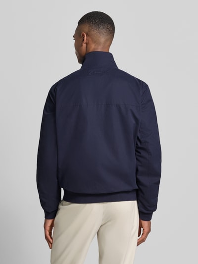 Männermodel trägt Jacke mit Stehkragen und Zweiwege-Reißverschluss van Gant in donkerblauw katoenmix, regular fit, steekzakken, labelstitching, ganzkörperansicht rückansicht.