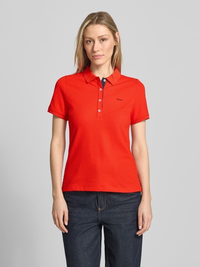 Frauenmodel trägt Slim Fit Poloshirt mit Label-Stitching von Gant, rot, Knopfleiste, Baumwoll-Elasthan-Mix, Ganzkörperansicht von vorne.