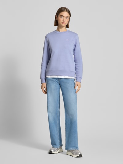 Modelka kobieca nosi Regular Fit Sweatshirt aus Baumwoll-Mix od Tommy Jeans, kolor jednolity, logo, długi rękaw, bawełniany mix, widok całej sylwetki z przodu.