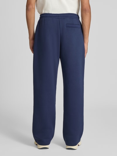 Männermodel trägt Straight Fit Sweatpants Baumwoll-Mix von REVIEW in Dunkelblau mit Gesäßtasche, Rückansicht, Ganzkörperansicht Rückansicht.