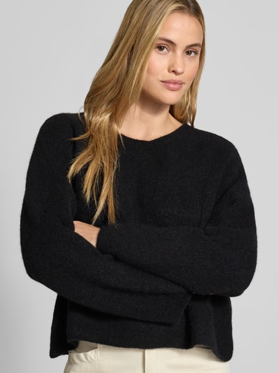 Frauenmodel trägt Strickpullover aus Alpaka-Leinen-Mix Modell 'VITOW' von American Vintage in Schwarz mit Rundhalsausschnitt, lockerer Passform, Nahaufnahme Oberkörper, Damen Strickpullover.