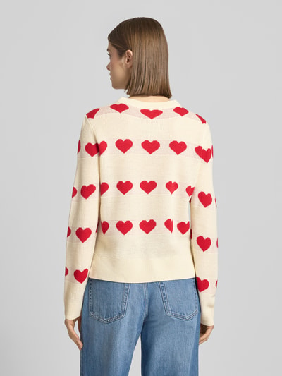 Frauenmodel trägt Regular Fit Pullover mit Allover-Muster Modell 'ELYNA' von Only, Strick, creme mit roten Herzen, Rückansicht Ganzkörperansicht.