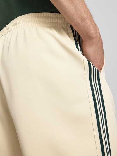 Männermodel trägt Regular Fit Sweatshorts mit elastischem Bund Modell 'RIBER' von Only & Sons in Beige mit Kontraststreifen, Nahaufnahme Oberkörper.