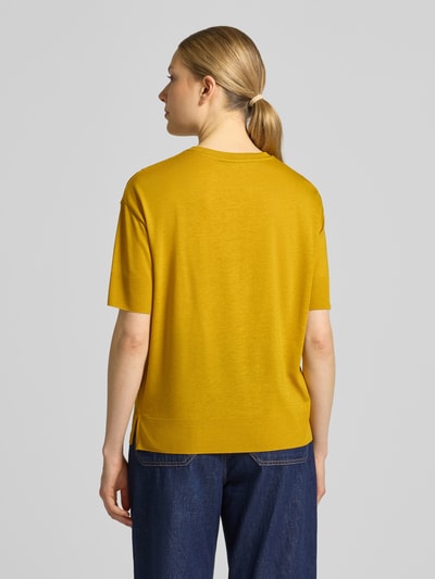 Modelka nosi T-Shirt aus Lyocell-Baumwoll-Mix mit Rundhalsausschnitt von Windsor, kolor musztardowy, krój regular fit, półrękaw, długość tyłu w rozmiarze 36: 59 cm, gładka tekstura, widok całej sylwetki z tyłu.