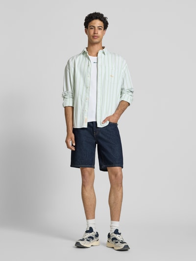 Männermodel trägt Regular Fit Jeansshorts aus reiner Baumwolle Modell 'EDGE' von Only & Sons, dunkelblaue Denim-Optik, 5-Pocket, Ganzkörperansicht von vorne.