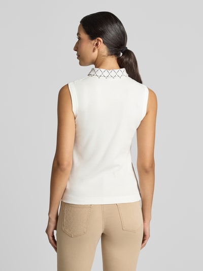 Vrouwenmodel draagt top met Polokraag en logomotief van Marc Cain, mix van katoen en elastaan, slim fit, knoopsluiting, ruglengte 53 cm bij maat 36. Ganzkörperansicht Rückansicht.