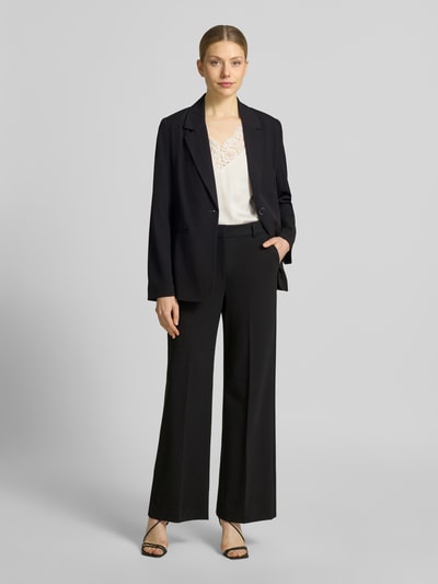Frauenmodel trägt Relaxed Fit Blazer mit Reverskragen Modell 'Danta' von B.Young, Material-Mix mit Viskose-Anteil, Paspeltaschen, Knopfverschluss, Rückenlänge 70 cm, Brustweite 35 cm, Ärmellänge 62 cm, schwarze Farbe, glatte Textur, Ganzkörperansicht von vorne.