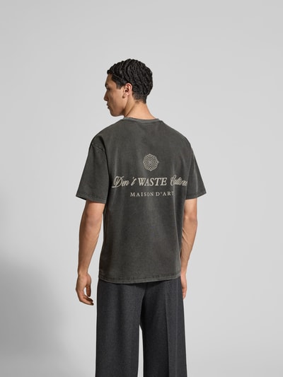 Männermodel trägt Regular Fit T-Shirt aus Baumwoll-Mix von Don't Waste Culture, Statement-Print, dunkelgrau, Rückenlänge 70 cm, Ganzkörperansicht Rückansicht.