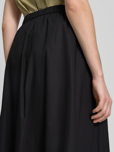 Frauenmodel trägt Ausgestellter Maxi-Rock aus reiner Baumwolle Modell 'CARAVAN' von Weekend Max Mara, Optik: Unifarben, Bundabschluss: Elastisch, Materialverarbeitung: Popeline, Material: Reine Baumwolle, Nahaufnahme Unterkörper Rückansicht.