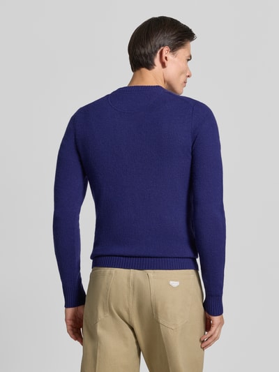 Männermodel trägt Slim Fit Strickpullover aus reiner Wolle mit Label-Stitching von MCNEAL in Blau, Ganzkörperansicht Rückansicht. Rückenlänge 66 cm, Ärmellänge 69 cm, gerippte Abschlüsse, Herren Strickpullover, feine Textur.