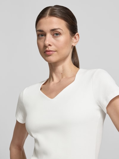 Vrouwenmodel draagt T-shirt met V-hals van More & More, mix van katoen en elastaan, strakke pasvorm, met korte mouwen, detailopname bovenlichaam.