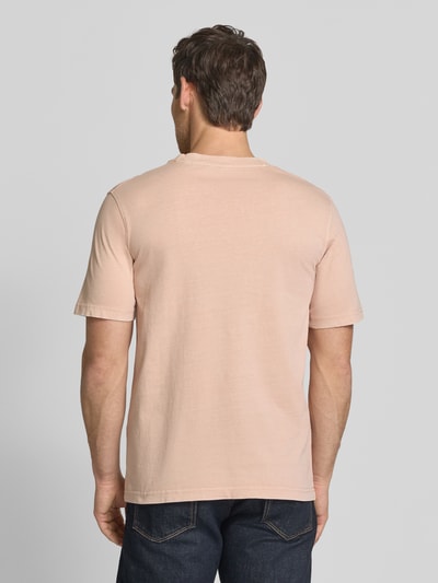 Männermodel trägt T-Shirt mit Label-Print Modell 'FELIX' von Jack & Jones Premium in Beige, reine Baumwolle, Ganzkörperansicht Rückansicht.