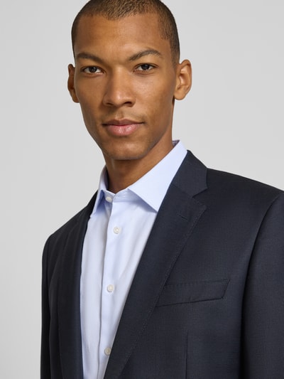 Männermodel trägt Slim Fit Businesshemd mit extra langem Arm von Jake*s, hellblau auf dunkelblauem Sakko, Nahaufnahme Oberkörper.