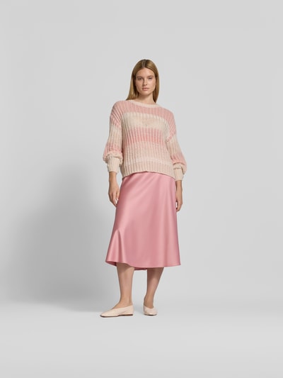 Frauenmodel trägt Midirock aus Satin mit Reißverschluss von Juvia in Rosé, schmale Passform, Midi-Länge, Ganzkörperansicht von vorne.