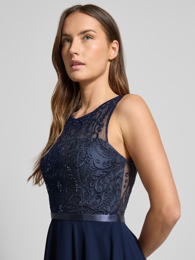 Kobiece model prezentuje Sukienka koktajlowa mit Strasssteinbesatz von LUXUAR FASHION, materiał trwały, krój lekko taliowany, jednokolorowy, okrągły dekolt, półprzezroczysty efekt, długość do kolan, obszycie z kamieni stras, zamek błyskawiczny, rozmiar 36: długość tyłu 96 cm, szerokość w biuście 41 cm, zbliżenie na górną część ciała z przodu.