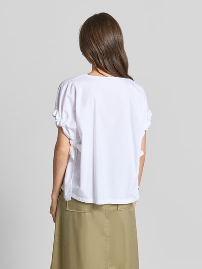 Frauenmodel trägt Relaxed Fit Bluse mit V-Ausschnitt von Marc Cain, weiße Baumwolle, Raffungen, kurzärmlig, Rückansicht Ganzkörperansicht.