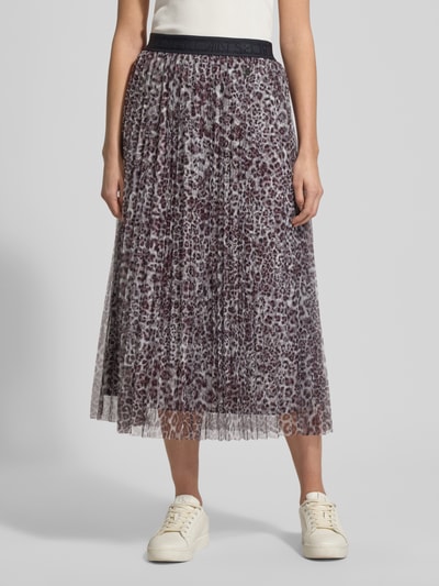Vrouwenmodel draagt Midirok in plooienlook met all-over dierenprint van Marc Cain, lichte A-lijn, elastische band, logostitching, tot. lengte 86 cm, bandwijdte 38 cm, maat 36. Ganzlichaamsaanzicht van voren.