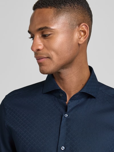 Männermodel trägt Slim Fit Businesshemd mit Haifischkragen von JOOP! Collection, Reine Baumwolle, Allover-Print, Nahaufnahme Oberkörper.