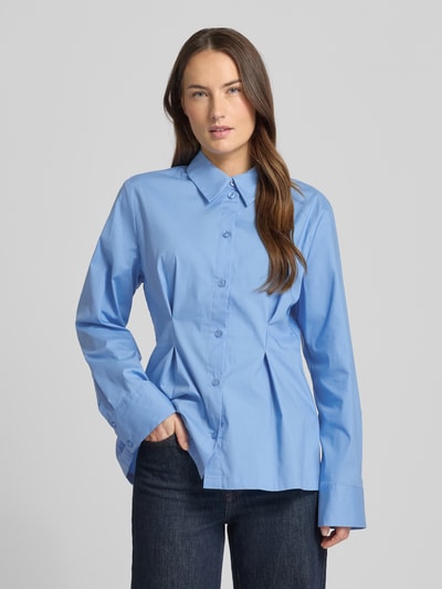 Frauenmodel trägt Hemdbluse aus Baumwoll-Mix Modell 'Zopy' von Gestuz in Hellblau, taillierte Passform, Sportmanschetten, Knopfleiste, Langärmelig, Ganzkörperansicht von vorne. Kontext: Damen Hemdbluse, elastischer Baumwoll-Mix, Hemdblusenkragen, Rückenlänge bei Größe 36: 68 cm, Ärmellänge: 63 cm.