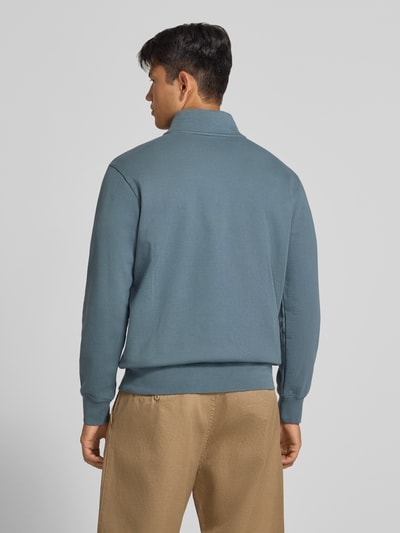 Männermodel trägt Regular Fit Pullover aus reiner Baumwolle von Levi's® in Blau, kombiniert mit beigefarbener Hose, Ganzkörperansicht Rückansicht.