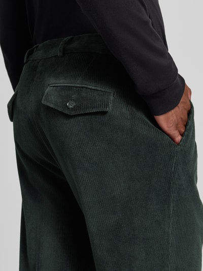 Mężczyzna nosi spodnie Zuitable Slim Fit Hose aus Baumwoll-Mix in Cord-Optik Modell 'Cliffer' z mieszanki bawełny, imitacja sztruksu, kieszenie wpuszczane i kieszeń z tyłu z guzikiem, kolor ciemnozielony, tekstura prążkowana, zapięcie na guzik i zamek błyskawiczny, Szerokość w rozmiarze 50: 37 cm, Długość wewnętrzna nogawki w rozmiarze 50: 76 cm, zdjęcie detaliczne z tyłu.