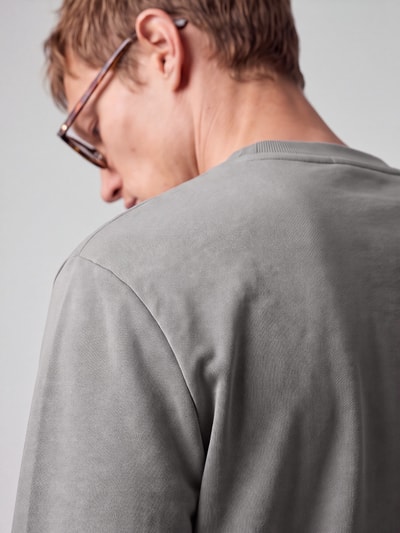 Männermodel trägt Regular Fit Sweatshirt aus reiner Baumwolle Modell 'Nespon' von HUGO in Grau, Jersey-Material, Nahaufnahme Rückansicht.