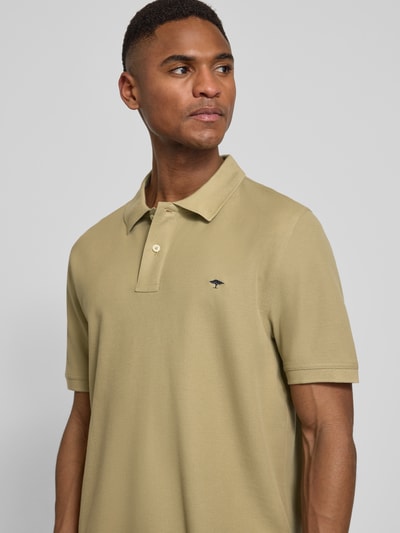 Männermodel trägt Regular Fit Poloshirt mit Logo-Stitching von Fynch-Hatton in Beige, reine Baumwolle, Nahaufnahme Oberkörper.