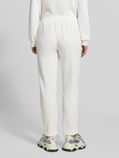 Frauenmodel trägt Sweatpants mit elastischem Bund und Logo von LIU JO SPORT, weißer Modal-Mix mit Stretch-Anteil, Regular-Fit, Ganzkörperansicht Rückansicht.