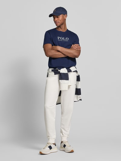 Männermodel trägt Regular Fit Pyjama-Oberteil aus reiner Baumwolle Modell 'CREW-SLEEP-TOP' von Polo Ralph Lauren Underwear, Optik: Unifarben, Passform: Regular Fit, Logo-Stitching, Label Print, Kragenform: Crew Neck, Ärmelform: Kurzarm, Material: Reine Baumwolle, Ganzkörperansicht von vorne.