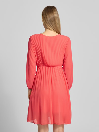 Frauenmodel trägt Kleid aus Viskose-Mix mit V-Ausschnitt von ZABAIONE in Koralle, semitransparent, taillierte Passform, Rückenlänge 94 cm, Ganzkörperansicht Rückansicht.