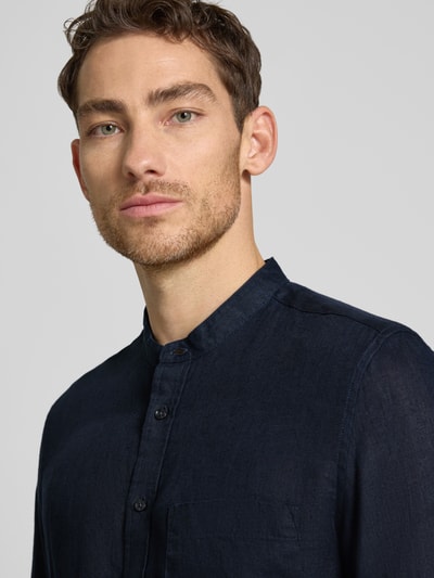 Männermodel trägt dunkles Slim-Fit Leinenhemd mit Stehkragen Modell 'Mandarin' von SEIDENSTICKER, mit Brusttasche und Knopfleiste, reine Leinen, Langärmelig, Nahaufnahme Oberkörper.
