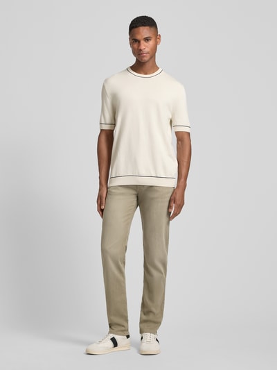 Męski model nosi Regular Fit Jeans mit Eingrifftaschen von bugatti, bawełniany materiał ze stretchem, kolor beżowy, krój regular fit, Szerokość w rozmiarze 32/32: 44 cm, długość nogawki wewnętrznej: 80 cm, widok całej sylwetki z przodu.