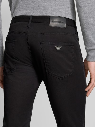 Männermodel trägt Slim Fit Jeans aus Baumwoll-Mix im 5-Pocket-Design von Emporio Armani, schwarze Farbe, Detailaufnahme Rückansicht. Elastischer Baumwoll-Mix, Knopf- und Reißverschluss, Bundweite 43 cm, Innenbeinlänge 82 cm.