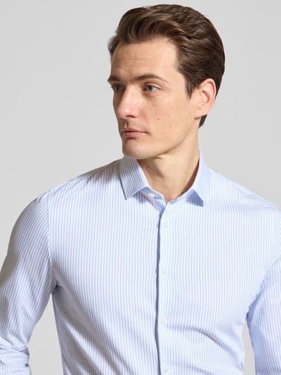 Męski model nosi Slim Fit Freizeithemd mit Kentkragen Modell 'Performance' od OLYMP No. Six, jasnoniebieskie paski, elastyczna bawełna, krój slim fit, długi rękaw, guzik, sportowe mankiety, perspektywa: zbliżenie na górną część ciała. Szerokość w rozmiarze 40: 45 cm, długość tyłu: 78 cm, długość rękawa: 68 cm.