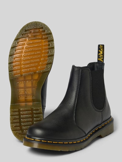 Produktfoto, Chelsea Boots aus echtem Leder mit Label-Patch von Dr. Martens, schwarze Oberfläche, profilierte gelb abgesetzte Sohle, abgerundete Passform, Absatzhöhe 4 cm, Schafthöhe 14 cm, Schaftweite 10 cm