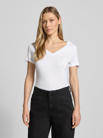 Modelka nosi Slim Fit T-Shirt aus reinem Lyocell od Guess, damski t-shirt z lyocellu, krój slim fit, dekolt w serek, wyhaftowane logo, długość tyłu w rozmiarze S: 58 cm, biel, gładka tekstura, widok na cały przód, zdjęcie całej sylwetki z przodu.