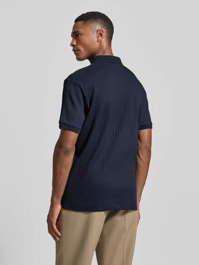 Männermodel trägt Regular Fit Poloshirt mit Baumwoll-Anteil Modell 'FAVE' von SELECTED HOMME, unifarben, Rippenstruktur, Rückansicht Ganzkörperansicht.