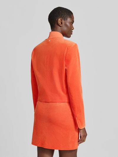 Frauenmodel trägt Regular Fit Kurzblazer aus reiner Baumwolle von Marc Cain in Orange, Cord, Rückenansicht, Kontext: Damen Kurzblazer von Marc Cain, Rundhalsausschnitt, Knopfleiste, Pattentaschen, Rückenlänge 49 cm, Brustweite 40 cm, Ärmellänge 64 cm. Ganzkörperansicht Rückansicht.