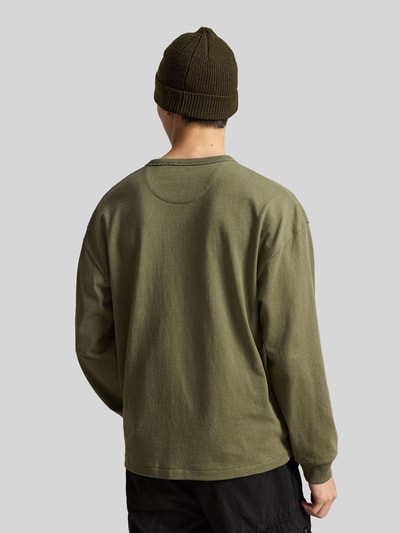 Männermodel trägt Relaxed Fit Langarmshirt aus reiner Baumwolle von Polo Ralph Lauren in Olivgrün, Ganzkörperansicht Rückansicht.
