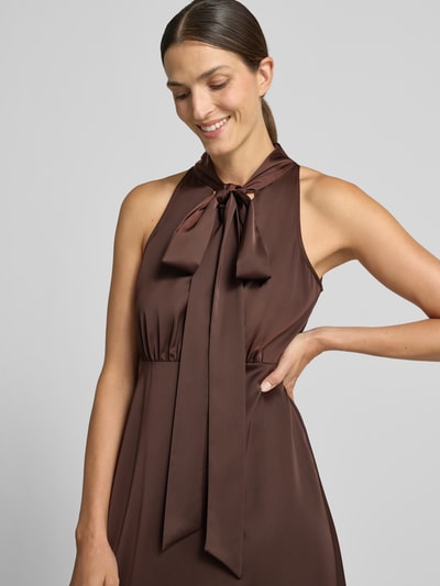 Frauenmodel trägt Maxikleid aus Satin Modell 'Thea' von YAS in Braun, taillierte Passform, elastischer Material-Mix, Nahaufnahme Oberkörper.