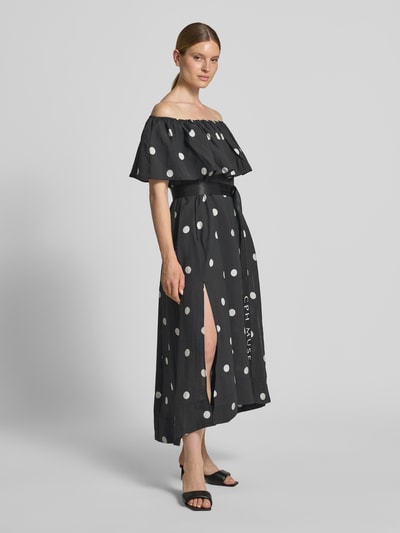 Frauenmodel trägt Midikleid mit Gürtel und Carmen-Ausschnitt Modell 'FIE' von Copenhagen Muse, schwarz mit weißen Punkten, Lyocell-Mix, taillierter Schnitt, Ganzkörperansicht von vorne.