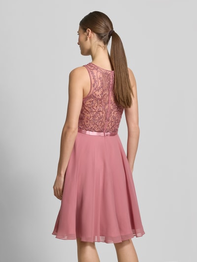 Vrouwenmodel draagt Cocktailkleid mit Rundhalsausschnitt van Luxuar, getailleerde fit, dichte voering, naadrits, ruglengte 157 cm, borstwijdte 40 cm, roze tinten, rugaanzicht, volledige lichaamsopname.