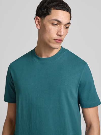 Männermodel trägt Relaxed Fit Oversized Shirt aus reiner Baumwolle von Marc O'Polo Denim in Optik: Unifarben, Label-Stitching-Applikation, Rundhals, Ärmelform: Kurzarm, Passform: Relaxed-Fit, Material: Reine Baumwolle, Nahaufnahme Oberkörper.