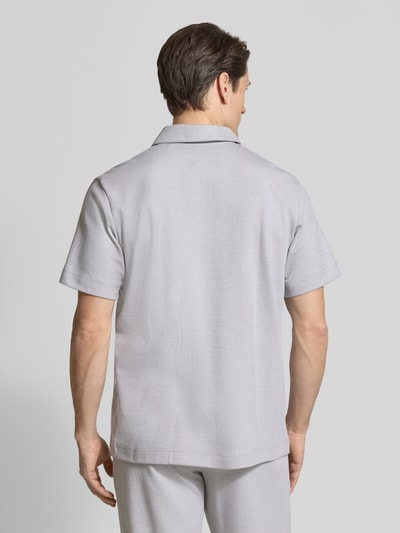 Mężczyzna-model ma na sobie Regular Fit Poloshirt mit Reißverschluss od Schiesser, mieszanka bawełny, kołnierzyk polo, zamek błyskawiczny, długość tyłu w rozmiarze 50: 71 cm, jasnoszara tkanina, struktura gładka, widok całej sylwetki od tyłu.