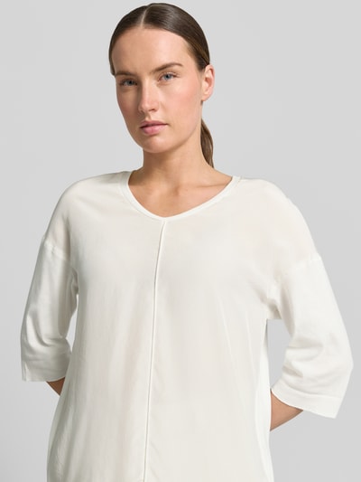 Frauenmodel trägt T-Shirt mit Ärmelaufschlag und Rundhalsausschnitt von Marc Cain, Damen T-Shirt aus Baumwoll-Mix mit Stretch-Anteil, Label-Detail, Straight Fit, Rückenlänge bei Größe 36: 62 cm, helle Farbe, schlichte Struktur, Nahaufnahme Oberkörper.