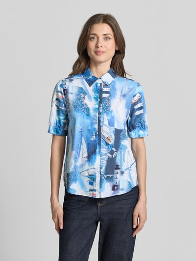 Frauenmodel trägt Regular Fit Hemdbluse mit Allover-Motiv-Print von Marc Cain, Reine Baumwolle, Hemdblusenkragen, Kurzärmelig, Elastische Ärmelabschlüsse, Rückenlänge 62 cm, Ärmellänge 28 cm, Farbkombination Blau-Weiß, leicht strukturierte Textur, Ganzkörperansicht von vorne.