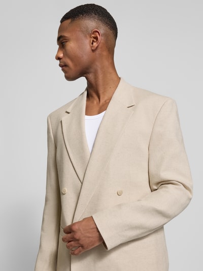 Mężczyzna nosi Slim Fit Sakko mit Leinen-Anteil od JAKE*S STUDIO MEN, jasny beż, elastyczna mieszanka bawełny i lnu, krój slim fit, dwurzędowa listwa guzikowa, kieszenie z lamówką, długość tyłu w rozmiarze M 67 cm, szerokość ramion w rozmiarze M 48 cm, długość rękawa w rozmiarze M 64 cm, zbliżenie na górną część ciała z przodu