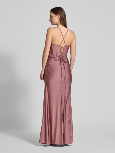 Frauenmodel trägt Slim Fit Abendkleid mit Gehschlitz von Mascara aus Satin mit Schnürverschluss und Spaghettiträgern, Ganzkörperansicht Rückansicht.