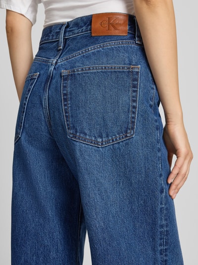 Frauenmodel trägt Wide Leg Jeans aus reiner Baumwolle Modell 'JULIU' von Calvin Klein Jeans, blaue Denim-Struktur, Nahaufnahme Rückansicht, Damen Wide & Loose Fit Jeans von Calvin Klein Jeans.